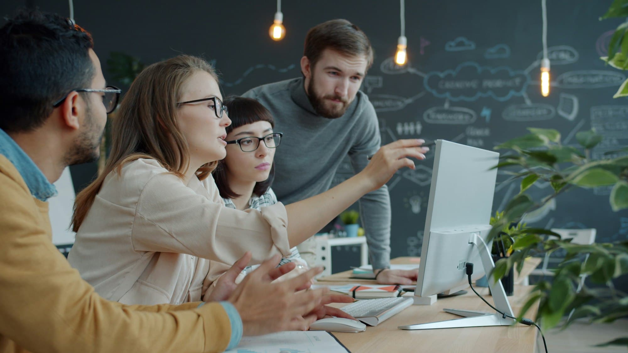 Team talking and pointing at a computer screen